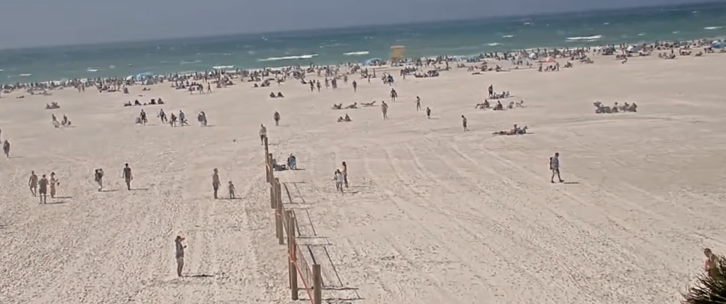 The Siesta Key live cam captures people playing sand volleyball and enjoying the beach.