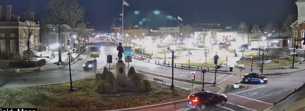 Traffic flows through the evening at a busy intersection.