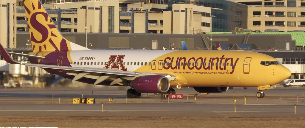 An airplane with the University of Minnesota logo and colors taxis down the runway
